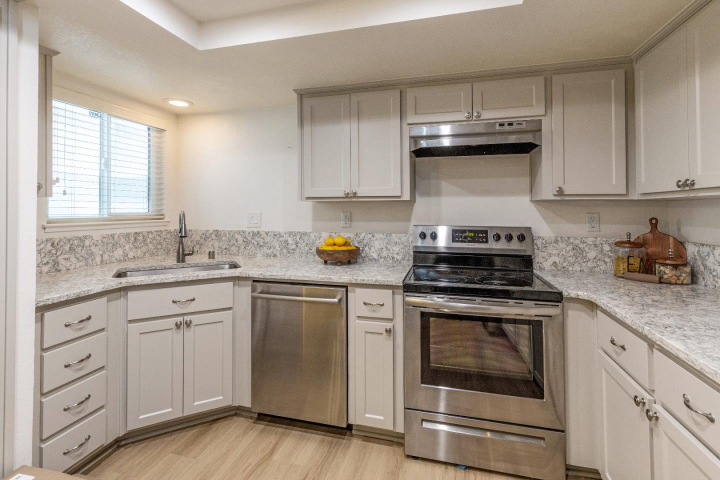 a kitchen with cabinets appliances a sink and a window