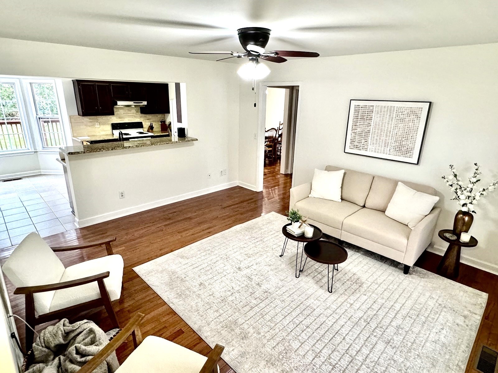 Freshly painted living area with large windows for natural light. Flows easily into kitchen and dining area