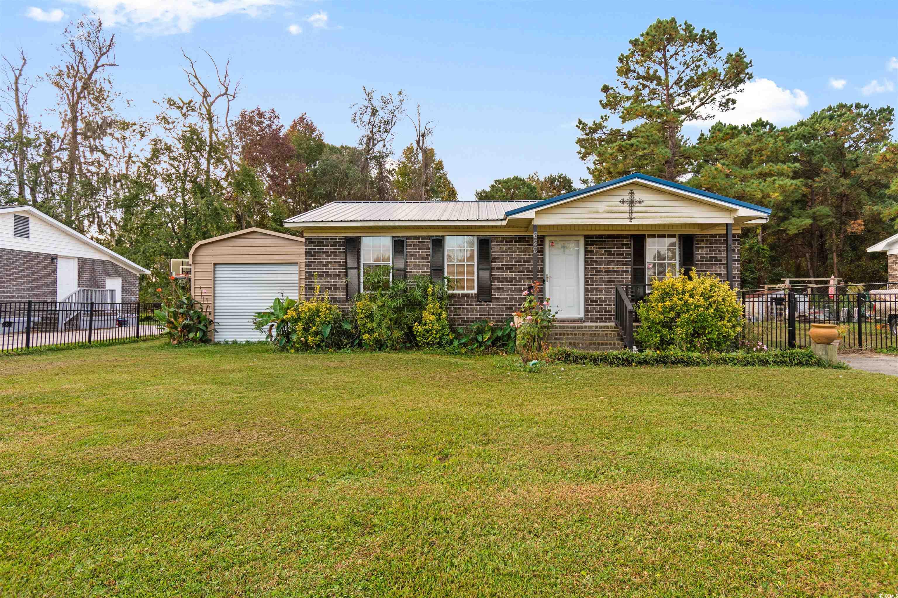 Ranch-style house featuring a front yard, a garage