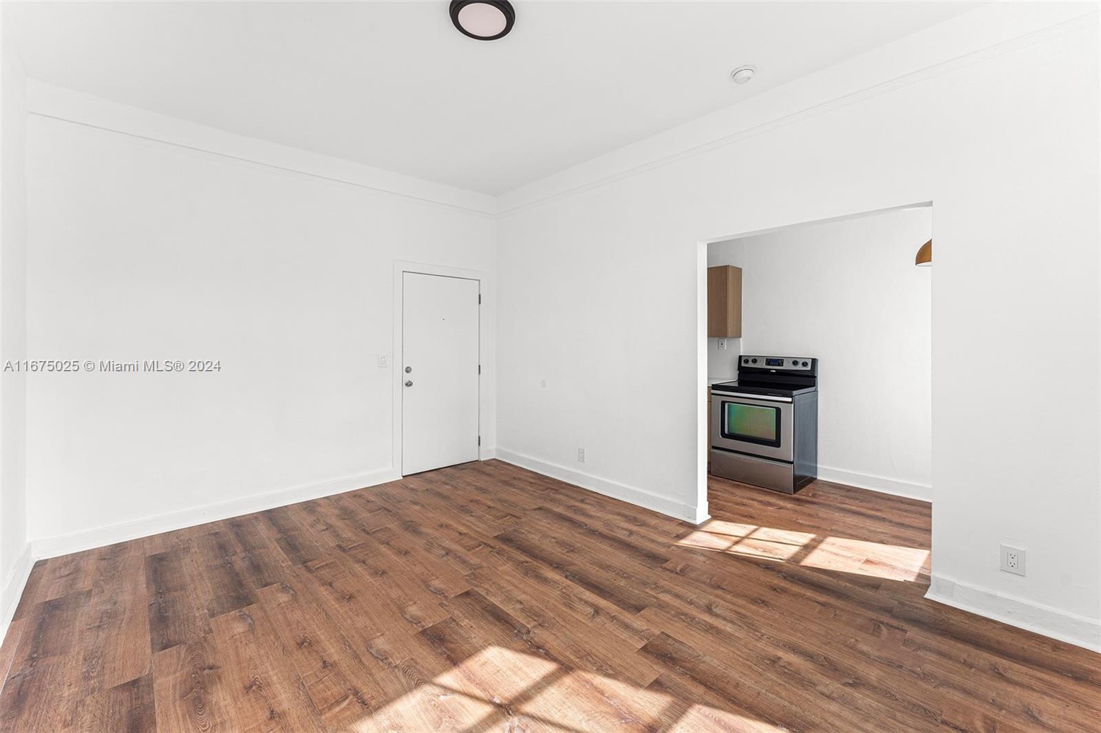 a view of empty room with wooden floor