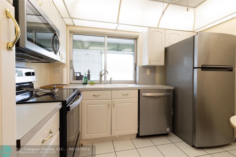 a kitchen with appliances a sink and cabinets