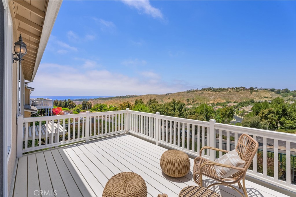 a view of a balcony with wooden floor table and chairs