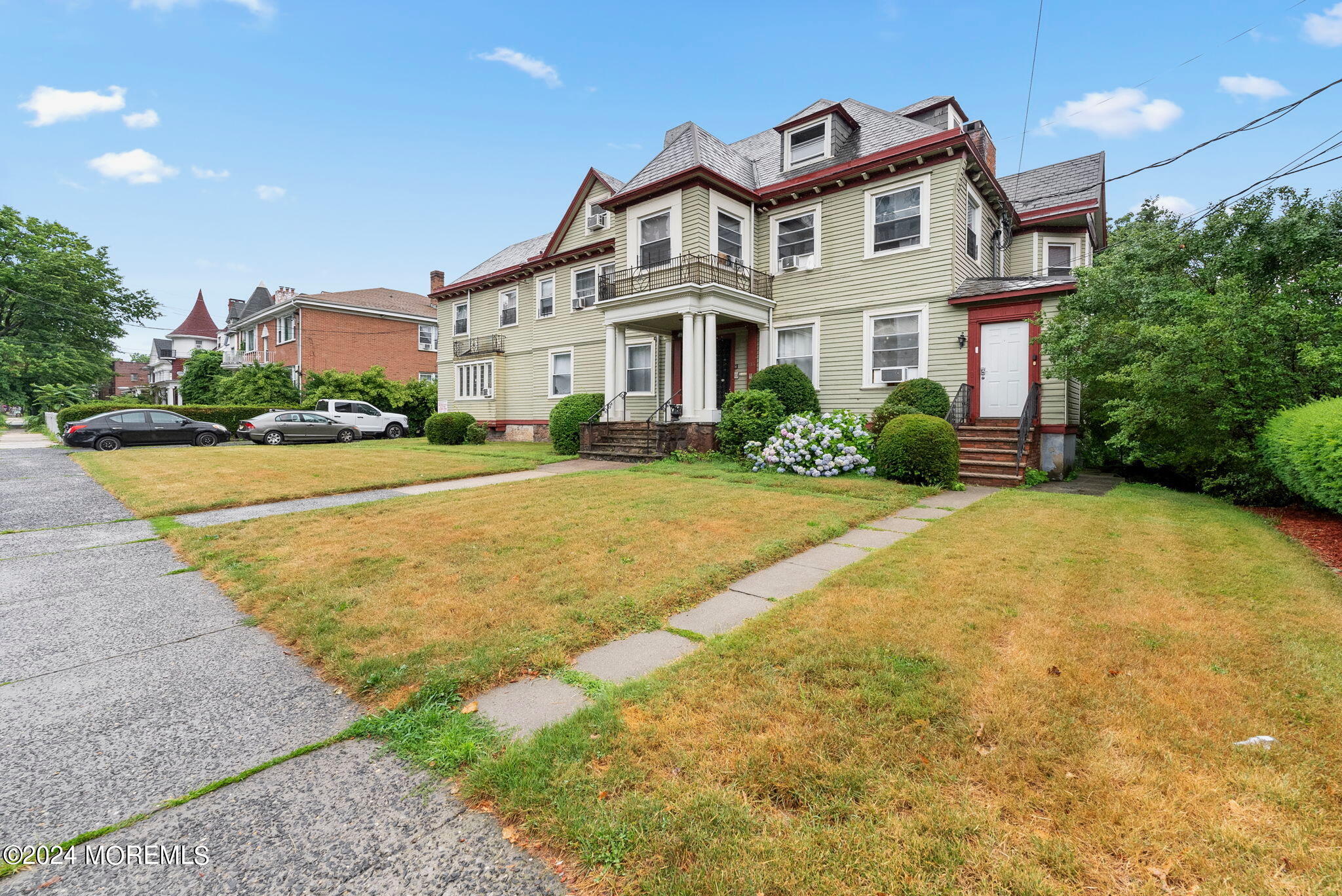 a front view of a house with a yard and potted plants