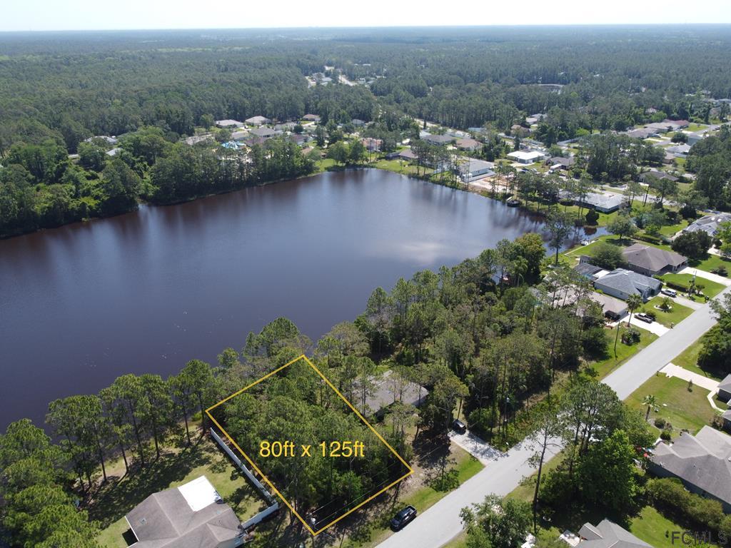 an aerial view of a house with a yard and lake view