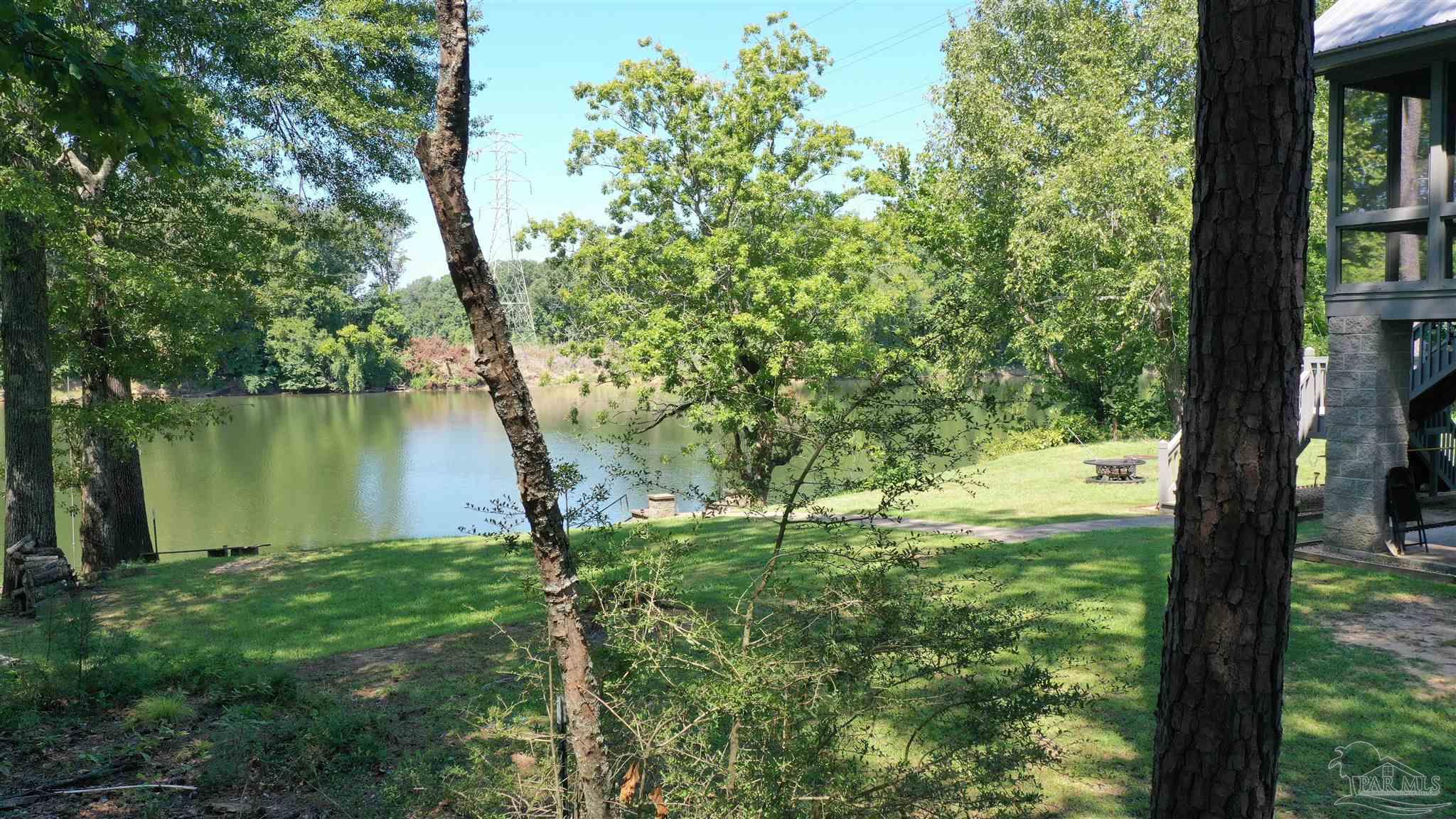 a backyard of a house with lots of green space and fountain in front of it