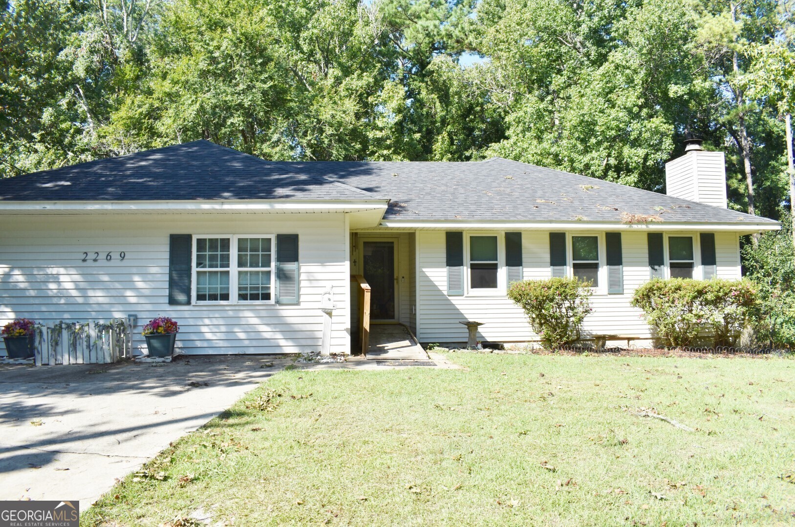 a front view of a house with a garden and yard