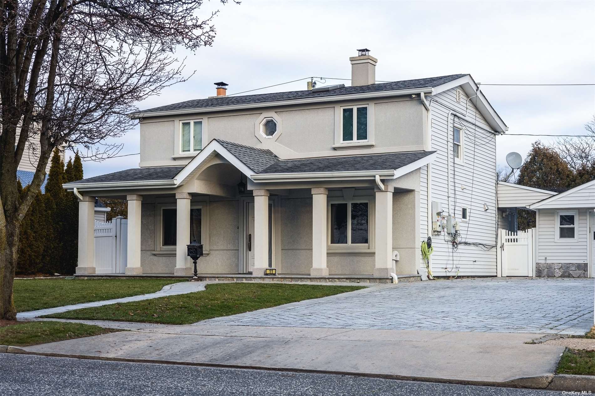 a view of a white house with large windows and a small yard