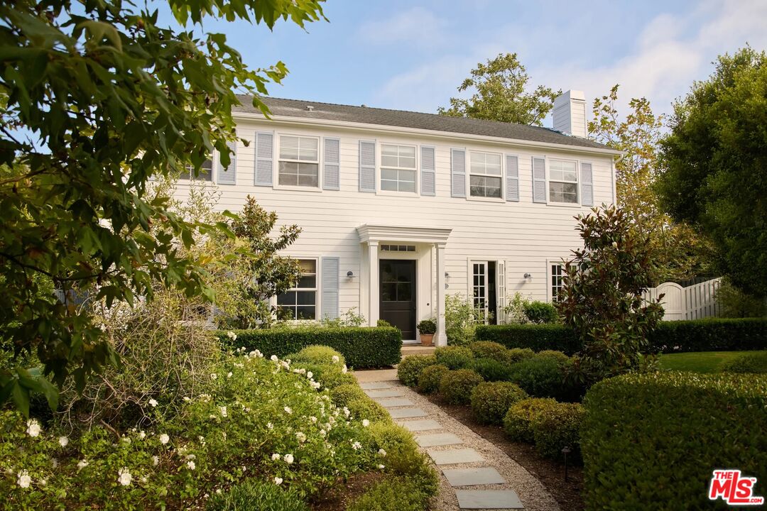 a front view of a house with a garden