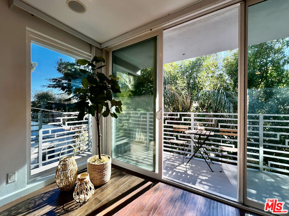 a view of a balcony with floor to ceiling windows with wooden floor