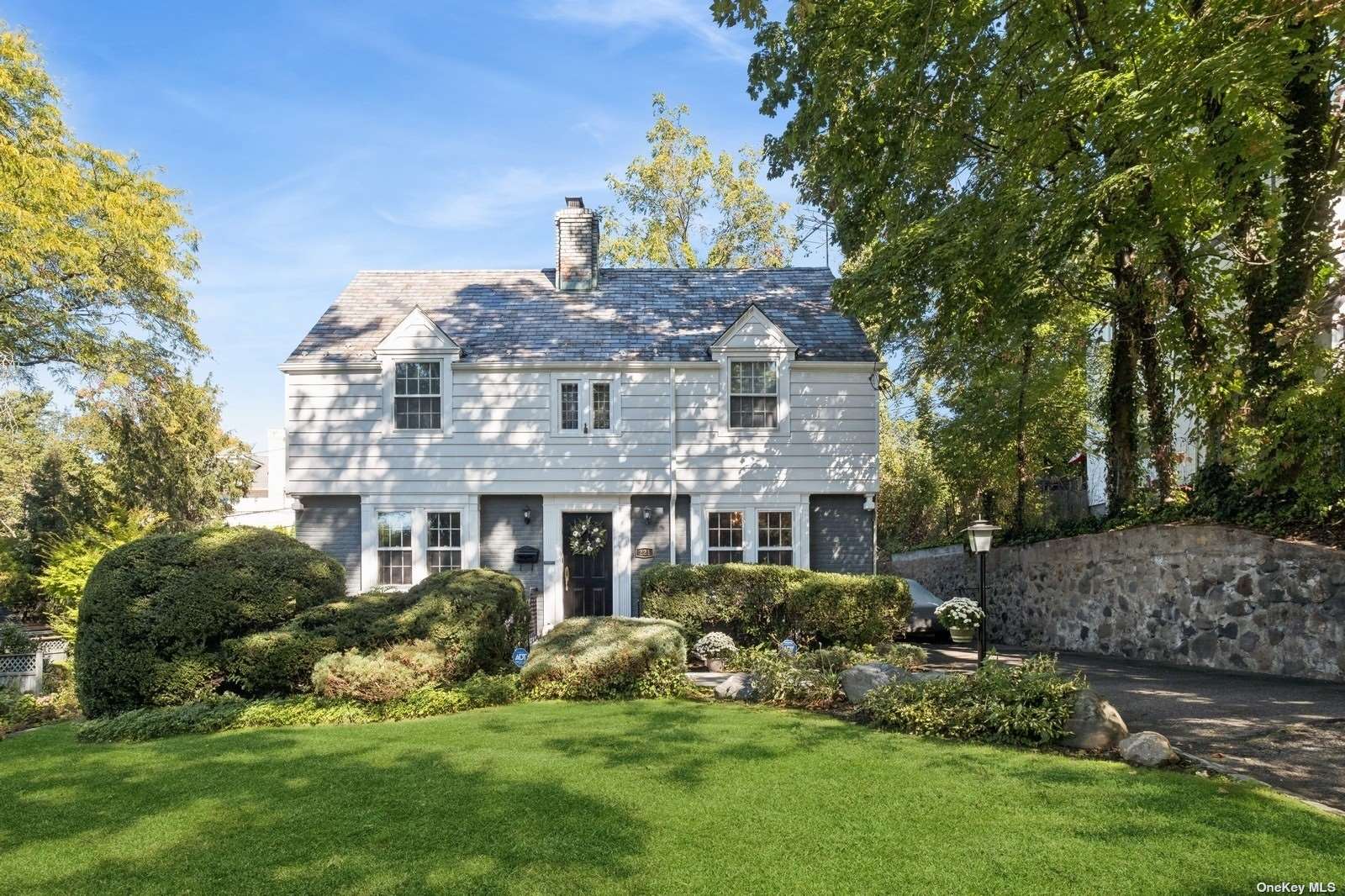 a front view of a house with a garden and plants