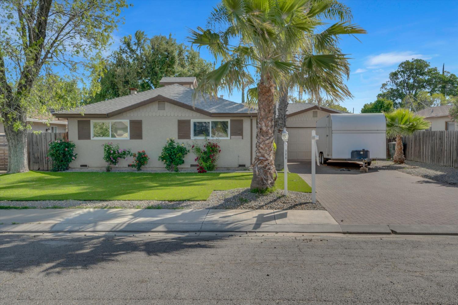 a view of a house with a yard and large trees