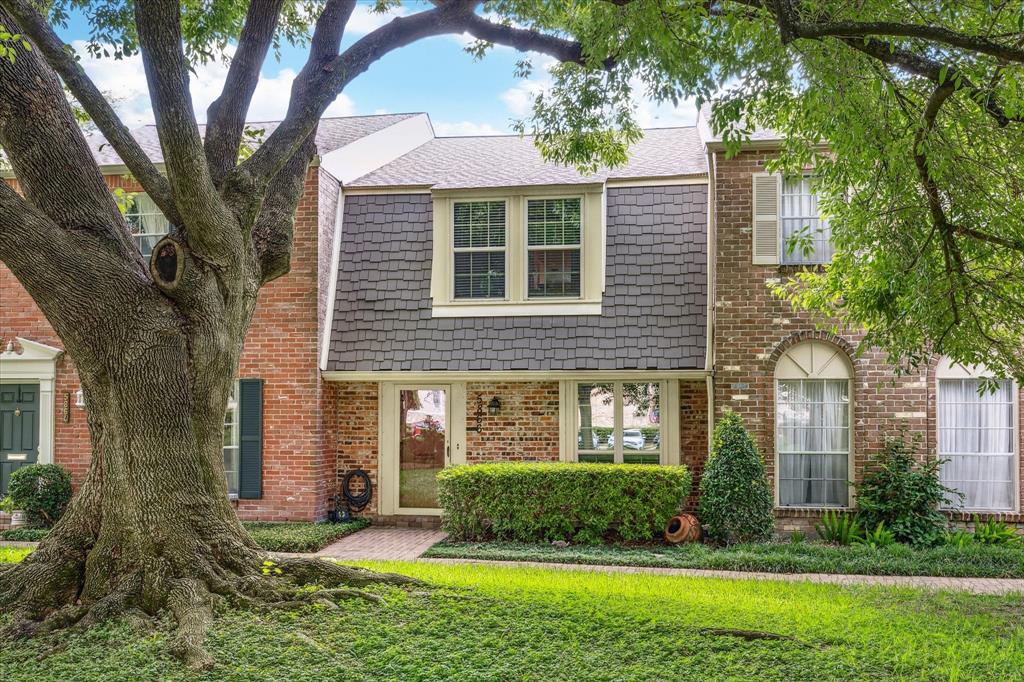 front view of a brick house with a yard