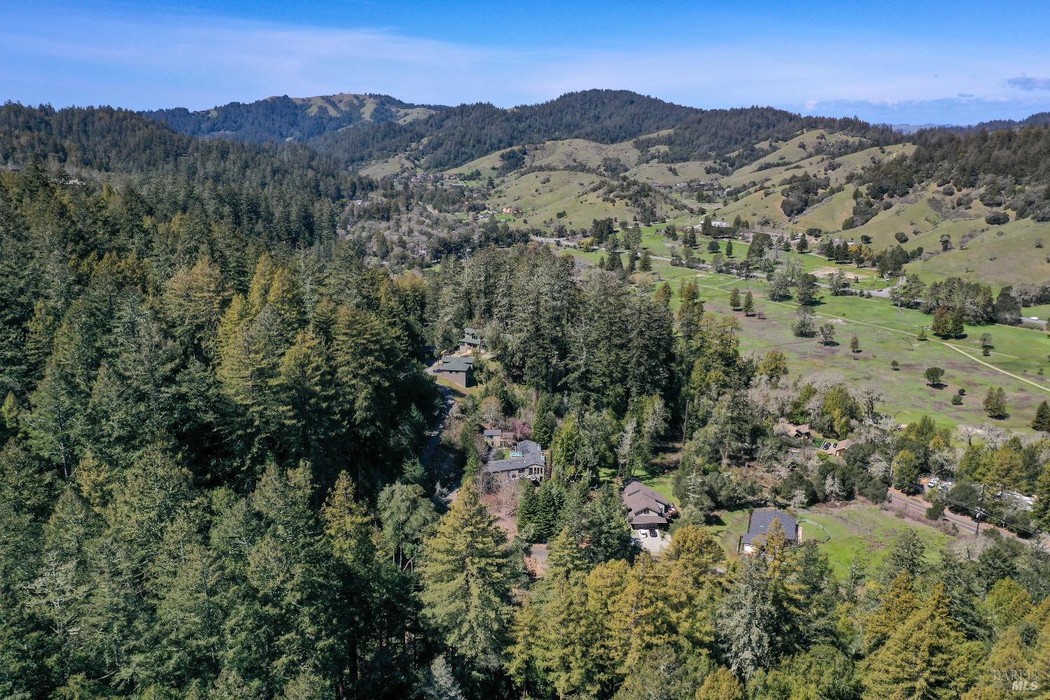 an aerial view of mountains residential house and green space