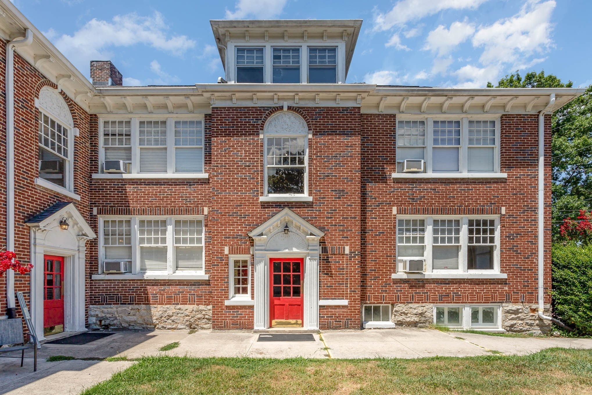 front view of a brick house with a yard