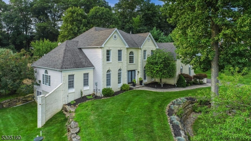 a aerial view of a house next to a big yard and large trees