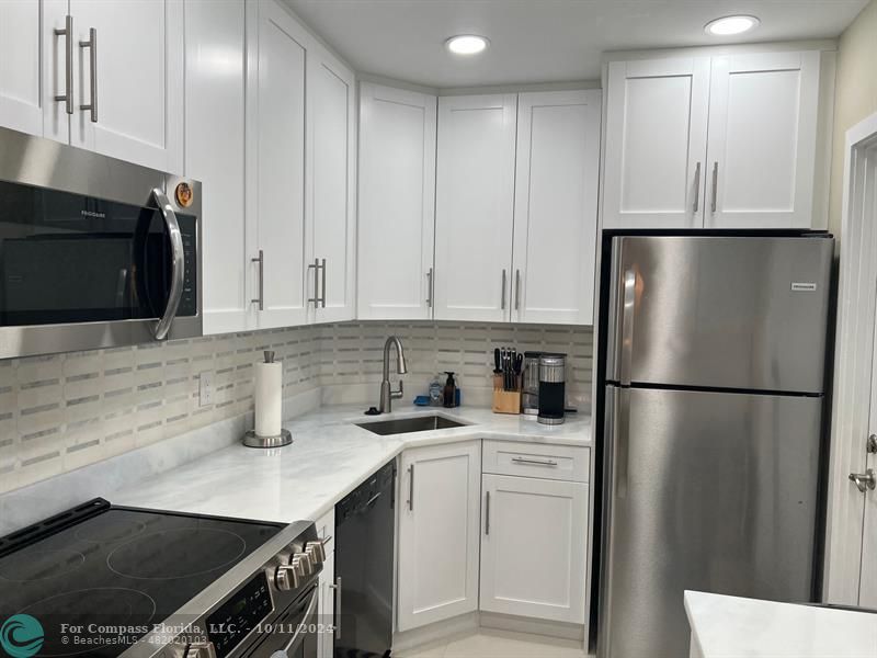 a kitchen with a sink a refrigerator and cabinets