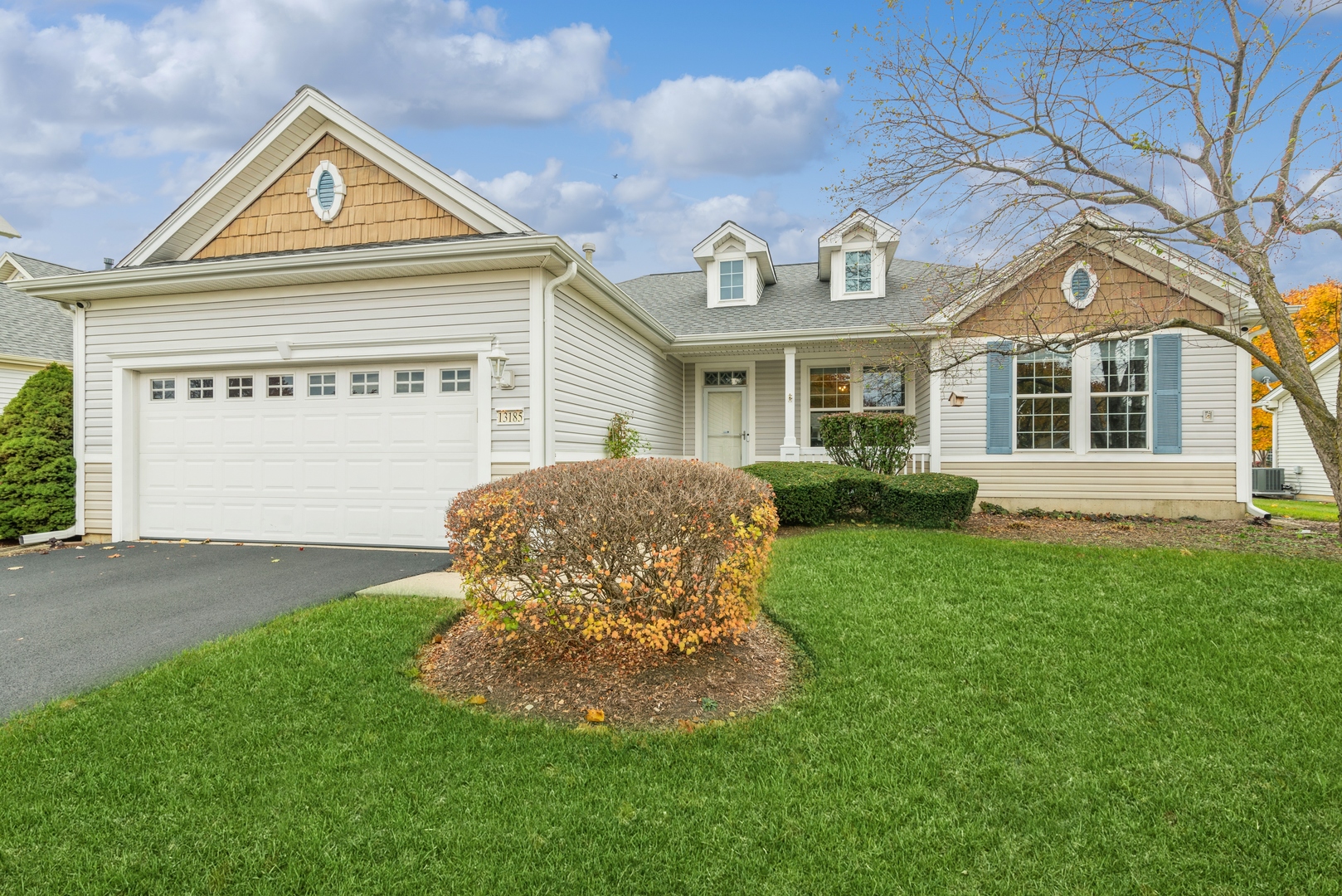 a front view of a house with a garden and plants