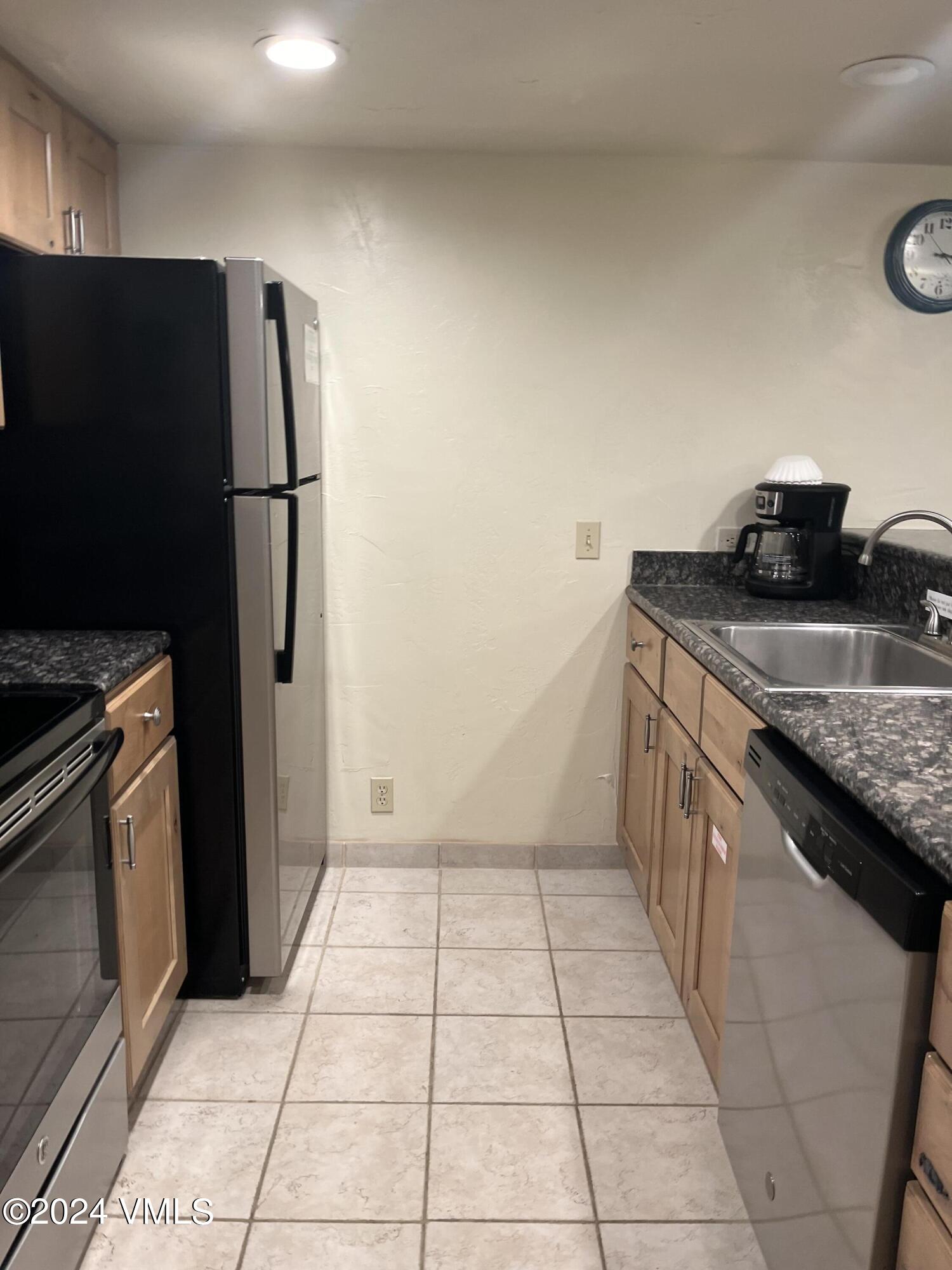 a kitchen with stainless steel appliances granite countertop a refrigerator and a stove