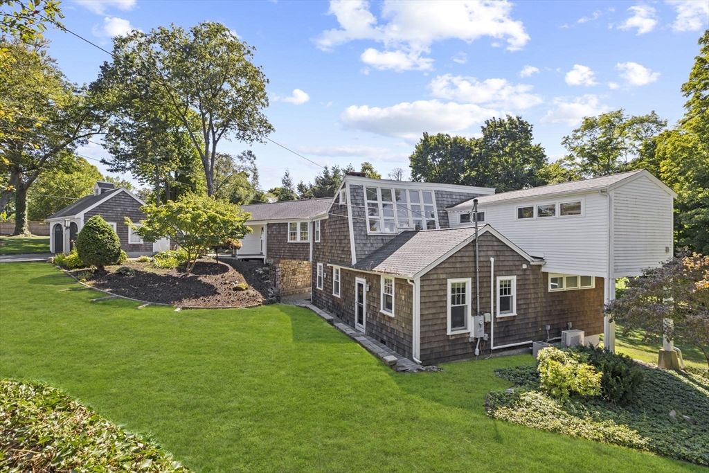 a view of a house with a big yard and large trees