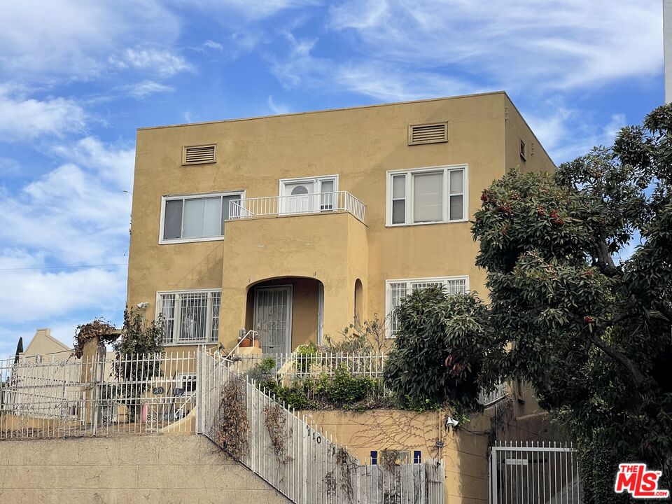 a front view of a house with yard and parking