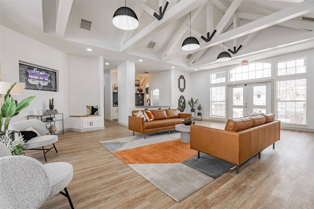 a living room with furniture wooden floor and a large window