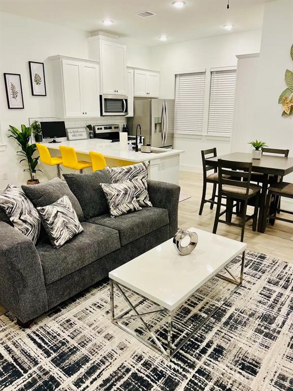 a living room with furniture and kitchen view