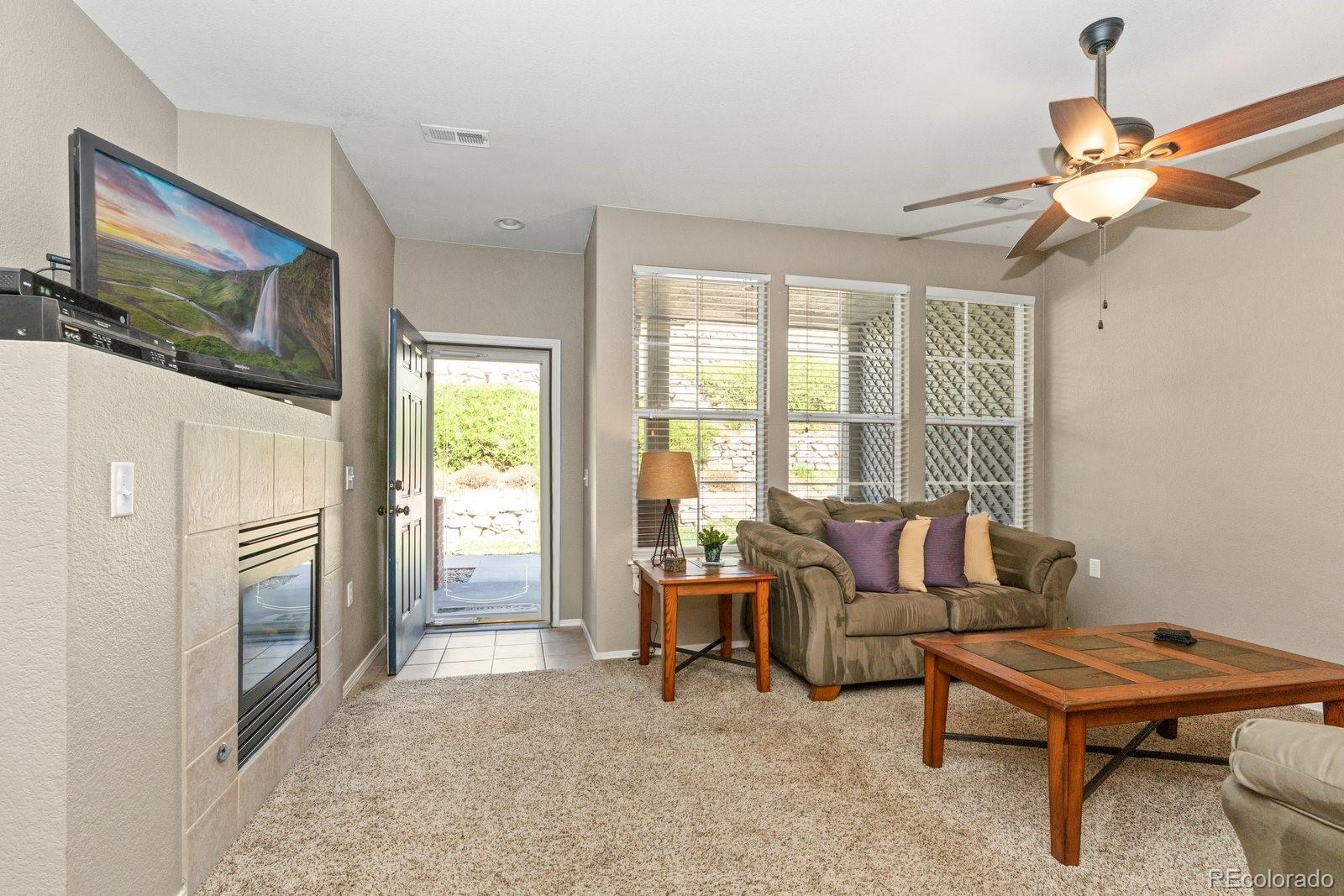 a living room with furniture a flat screen tv and a window