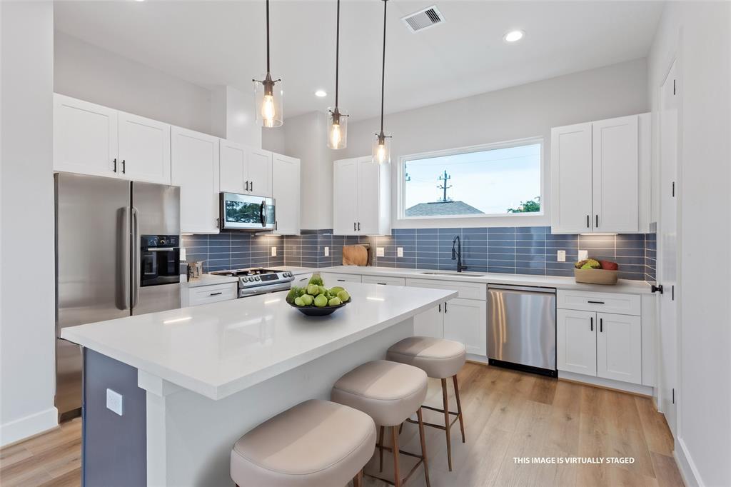 a kitchen with white cabinets and stainless steel appliances