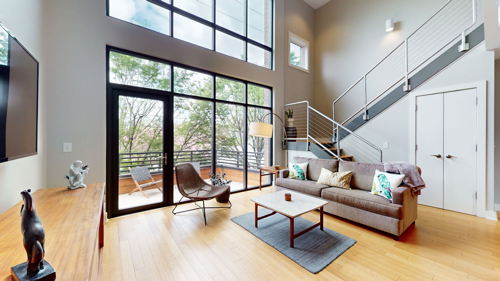 a living room with furniture and floor to ceiling windows