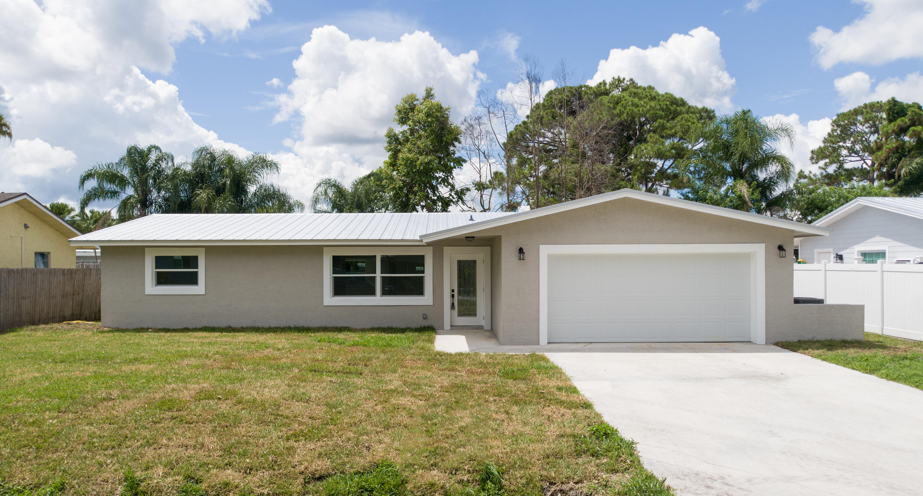 a front view of house with yard and trees around