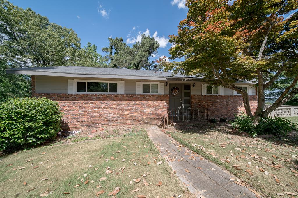 a front view of house with yard and trees around