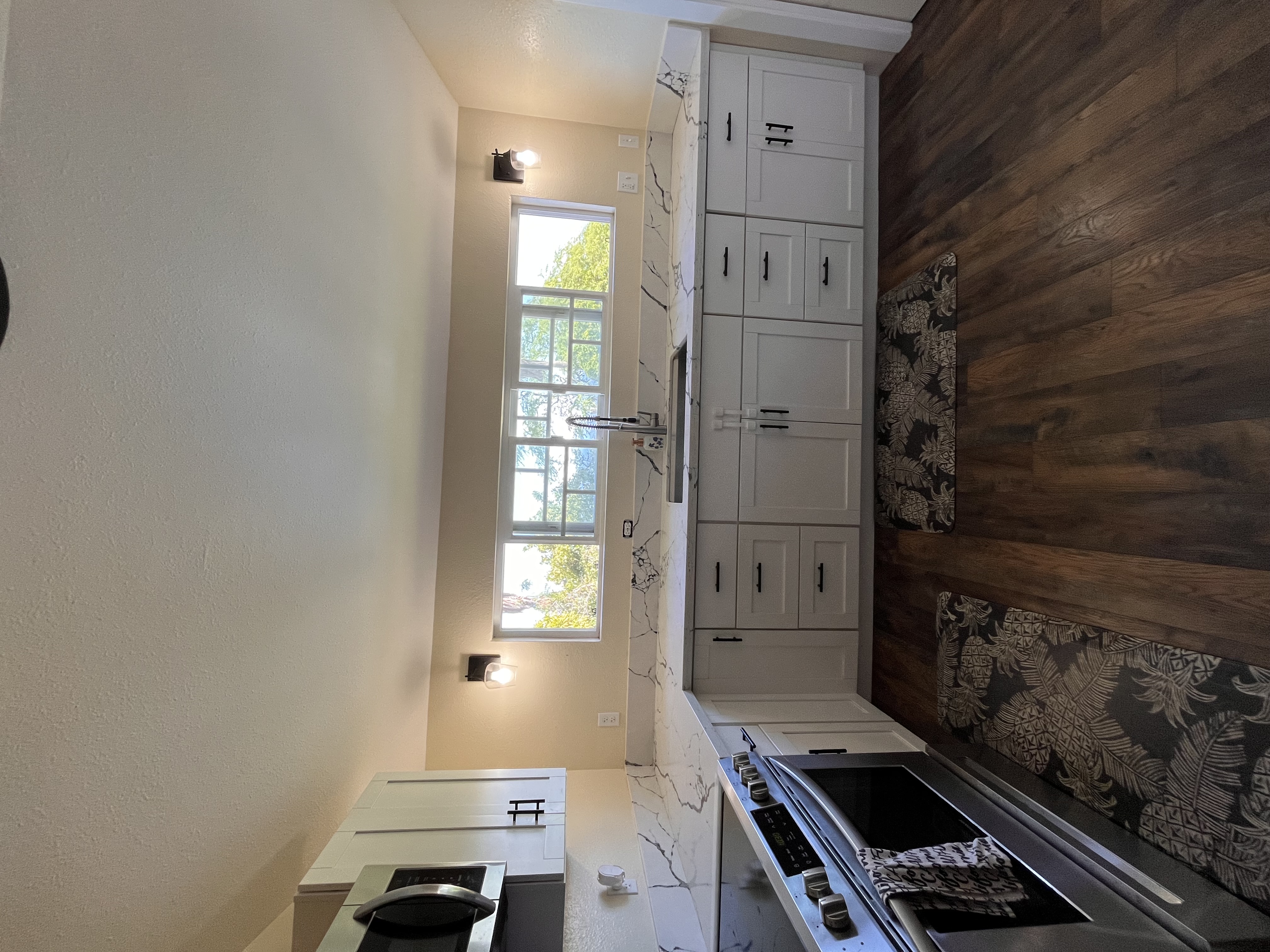 a view of a kitchen with a sink wooden floor and a window