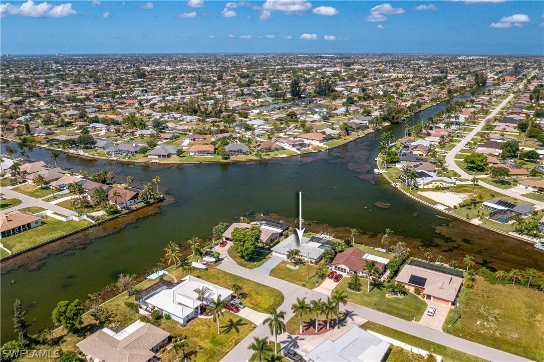 an aerial view of a house with a lake