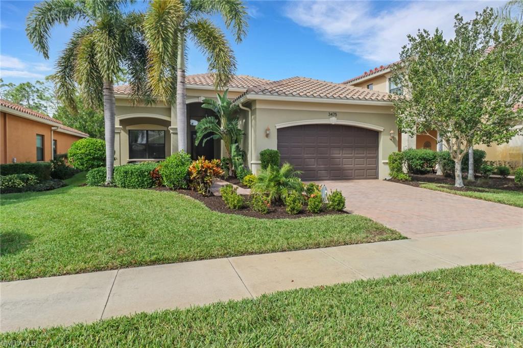 Mediterranean / spanish-style house with a front yard and a garage