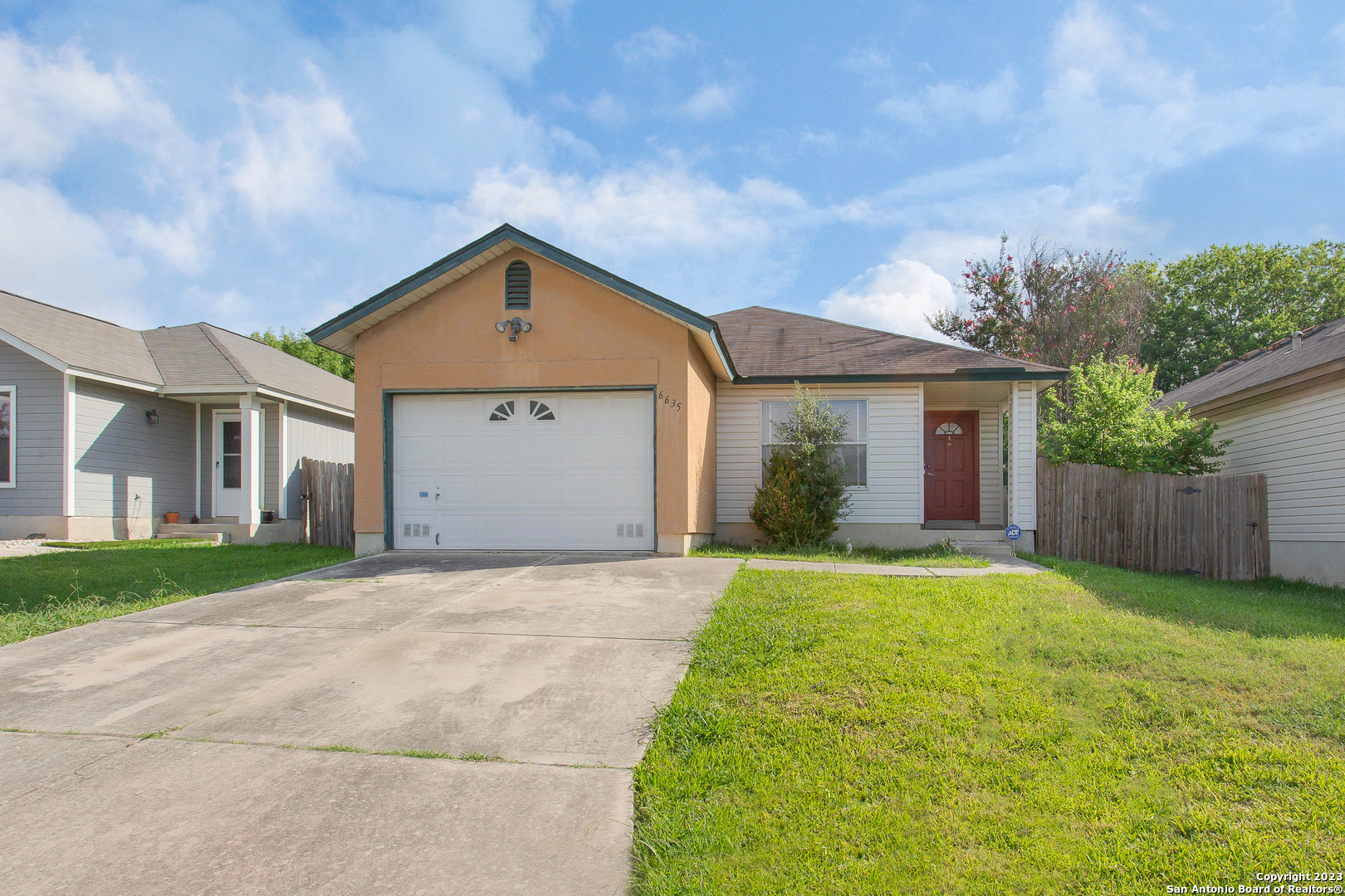 front view of a house with a yard and garage