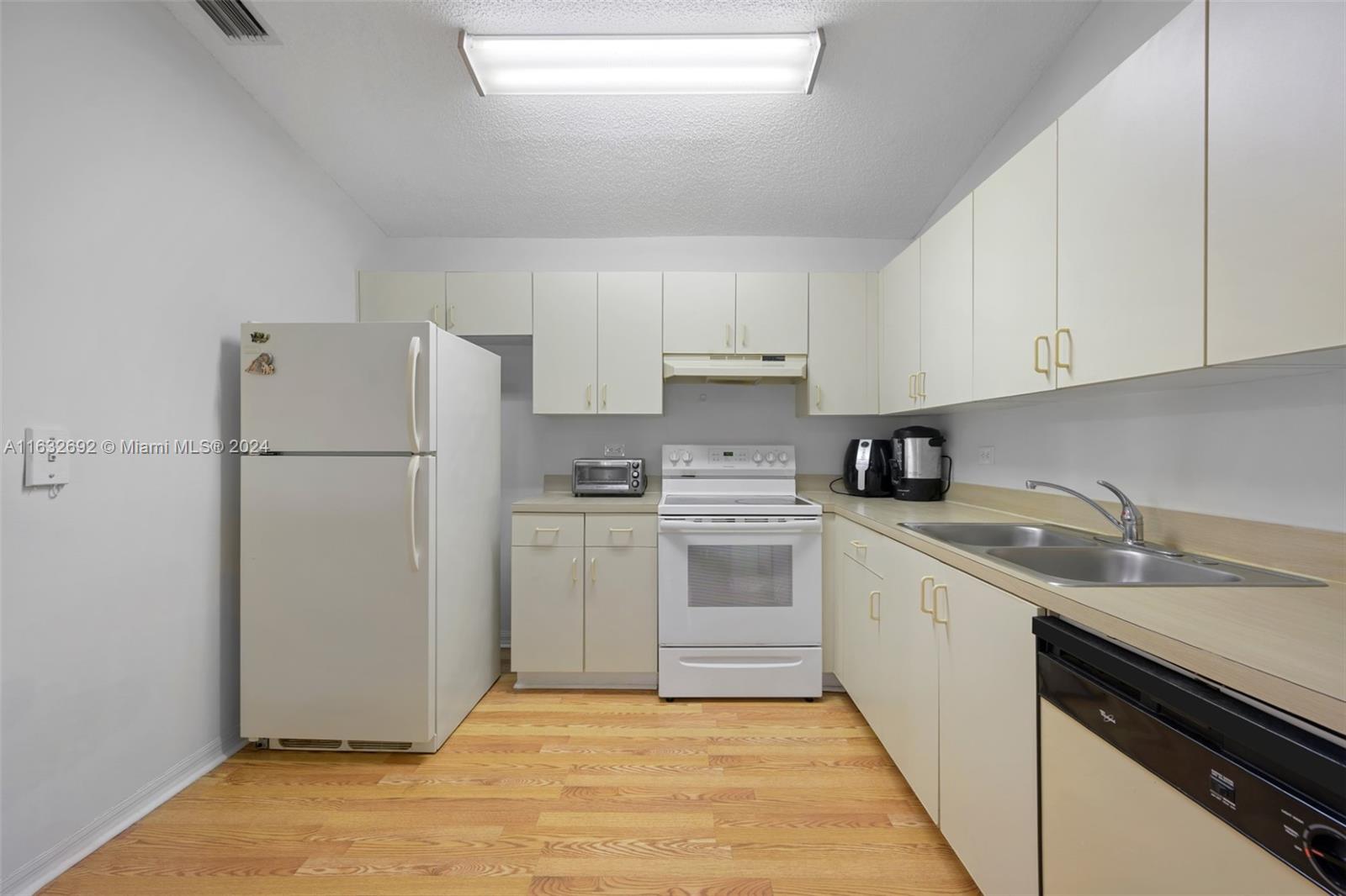 a kitchen with a refrigerator sink and cabinets