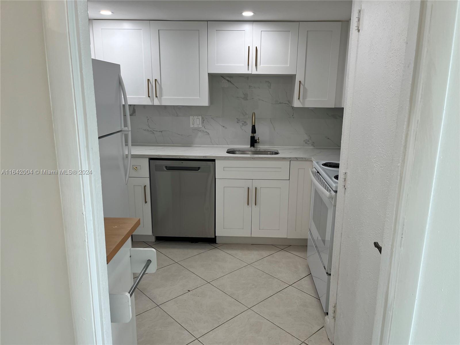 a kitchen with stainless steel appliances a sink stove and refrigerator