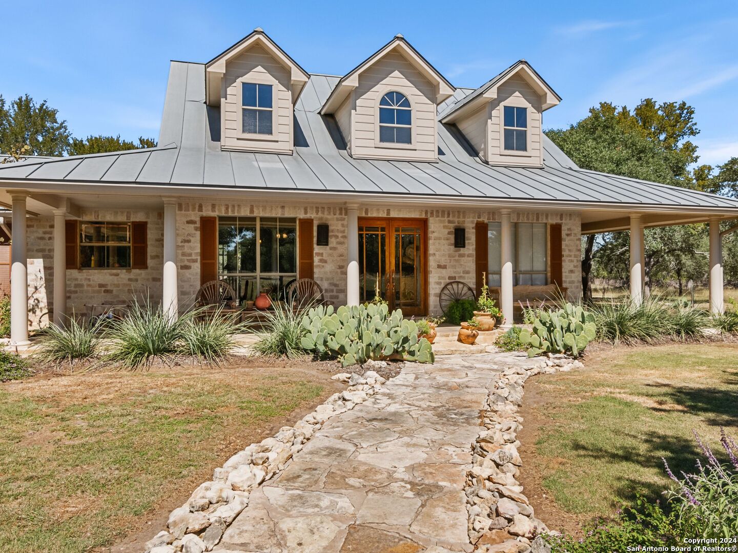 a front view of a house with garden and plants