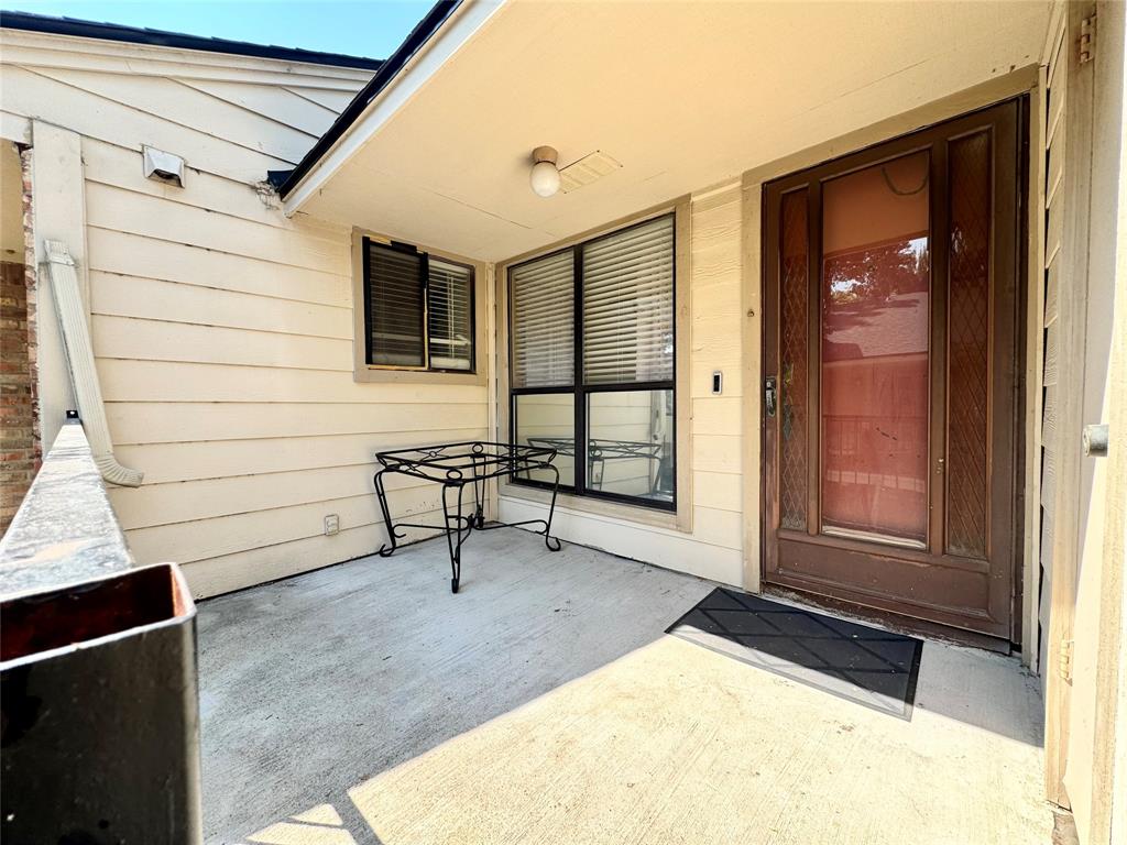 a view of a porch with a table and chairs