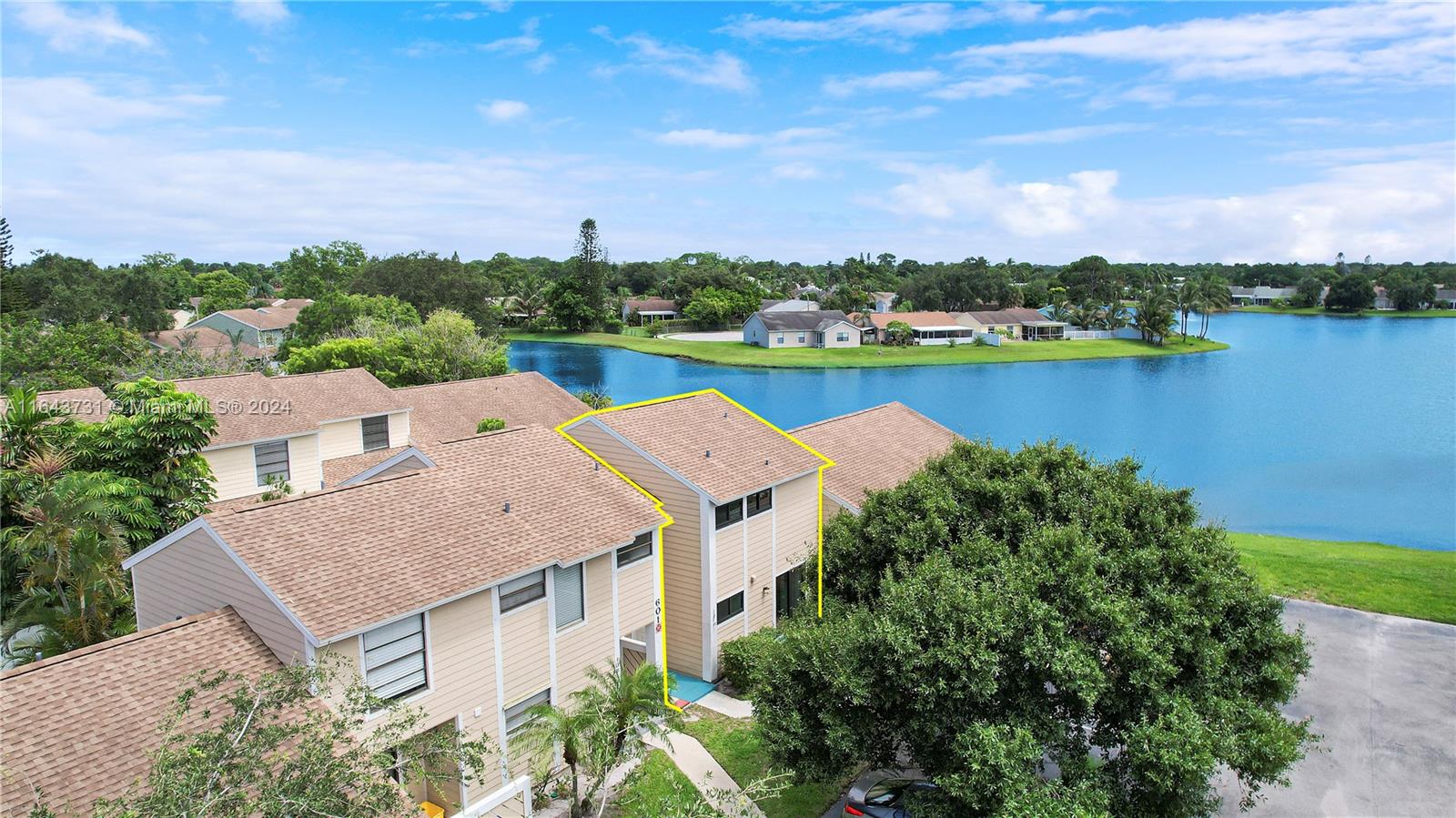 an aerial view of a house with a garden and lake view