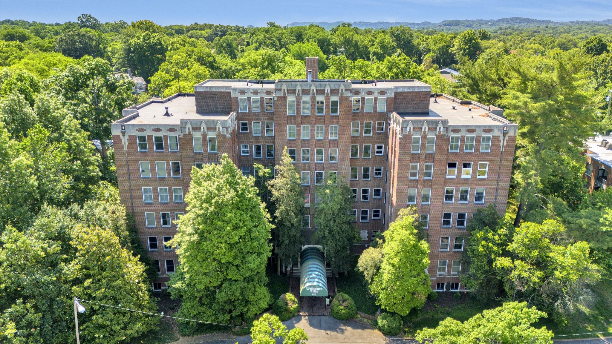 a front view of a multi story building with a yard