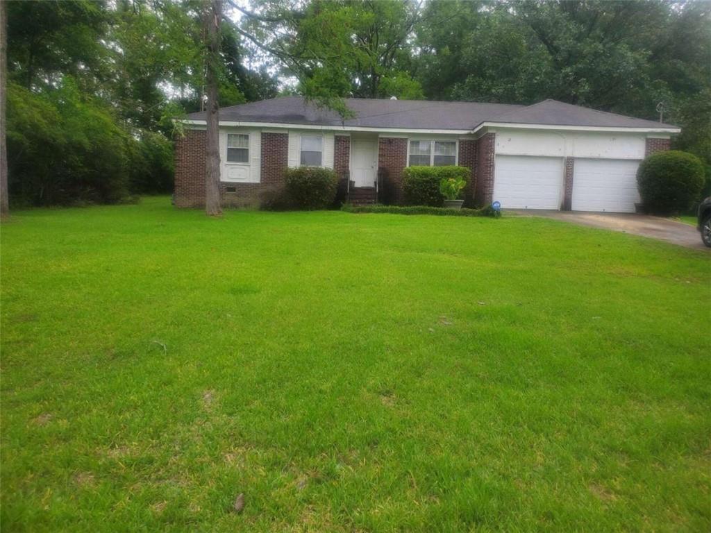 a view of a yard in front of a house with large trees