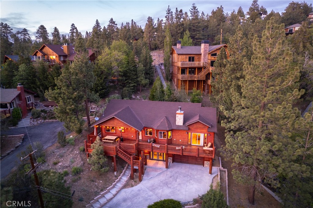 an aerial view of a house with a yard and a large tree