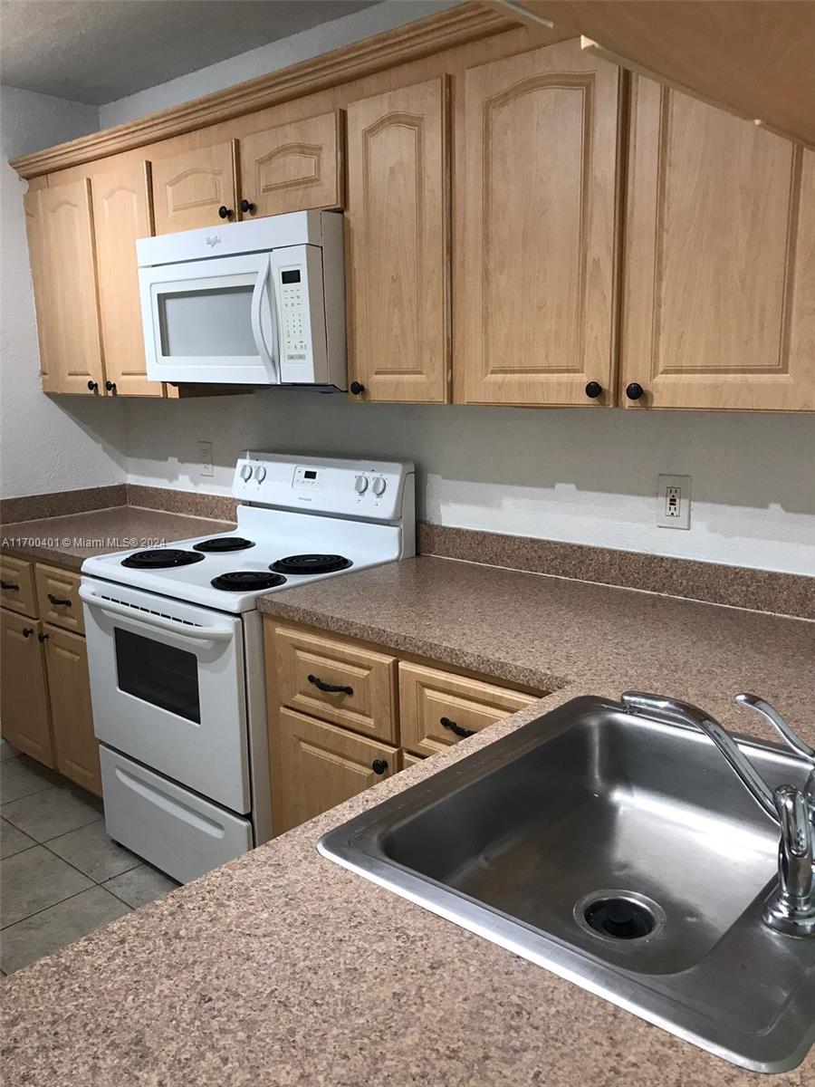 a kitchen with stainless steel appliances granite countertop a sink and a stove