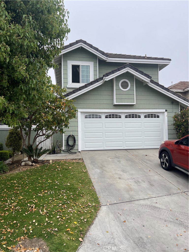 a view of a house with a yard and a garage