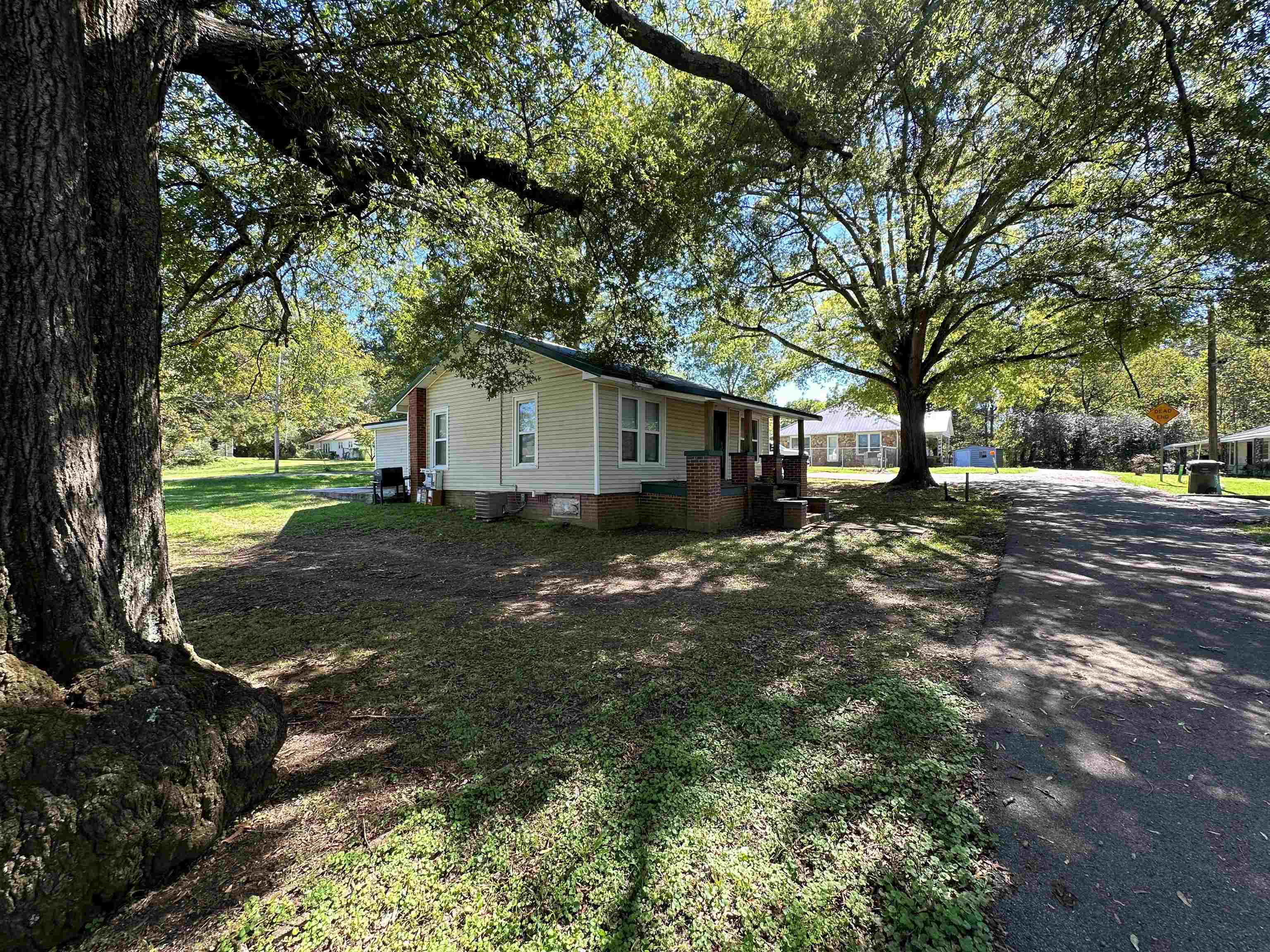 a view of a yard with a house and a large tree