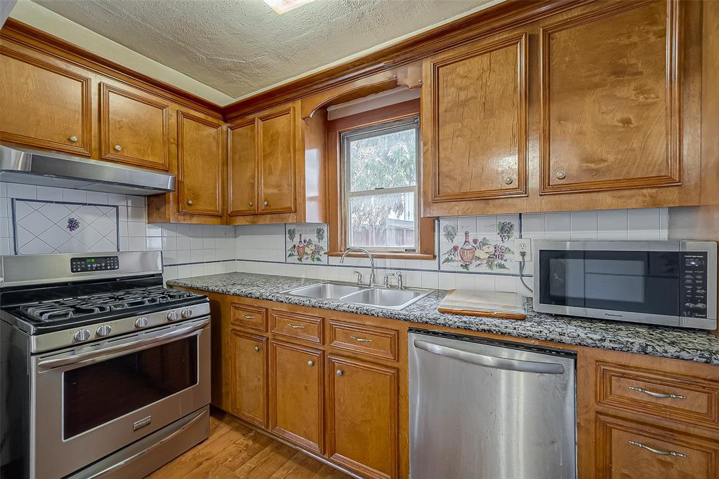 Enhancing the kitchen's charm are the warm wood floors that infuse a sense of coziness and natural elegance into the space. Not only do the wood floors create a welcoming atmosphere, but they also add a touch of warmth to the overall design.