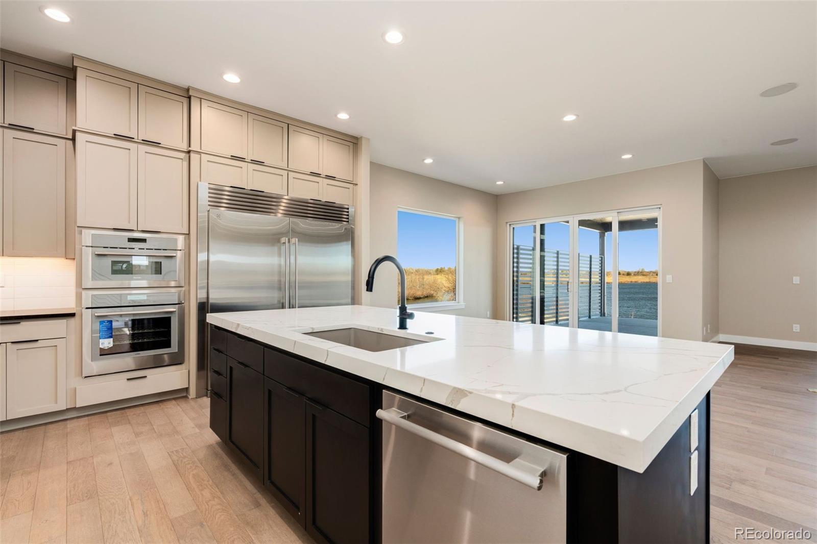 a kitchen with stainless steel appliances granite countertop a sink refrigerator and cabinets