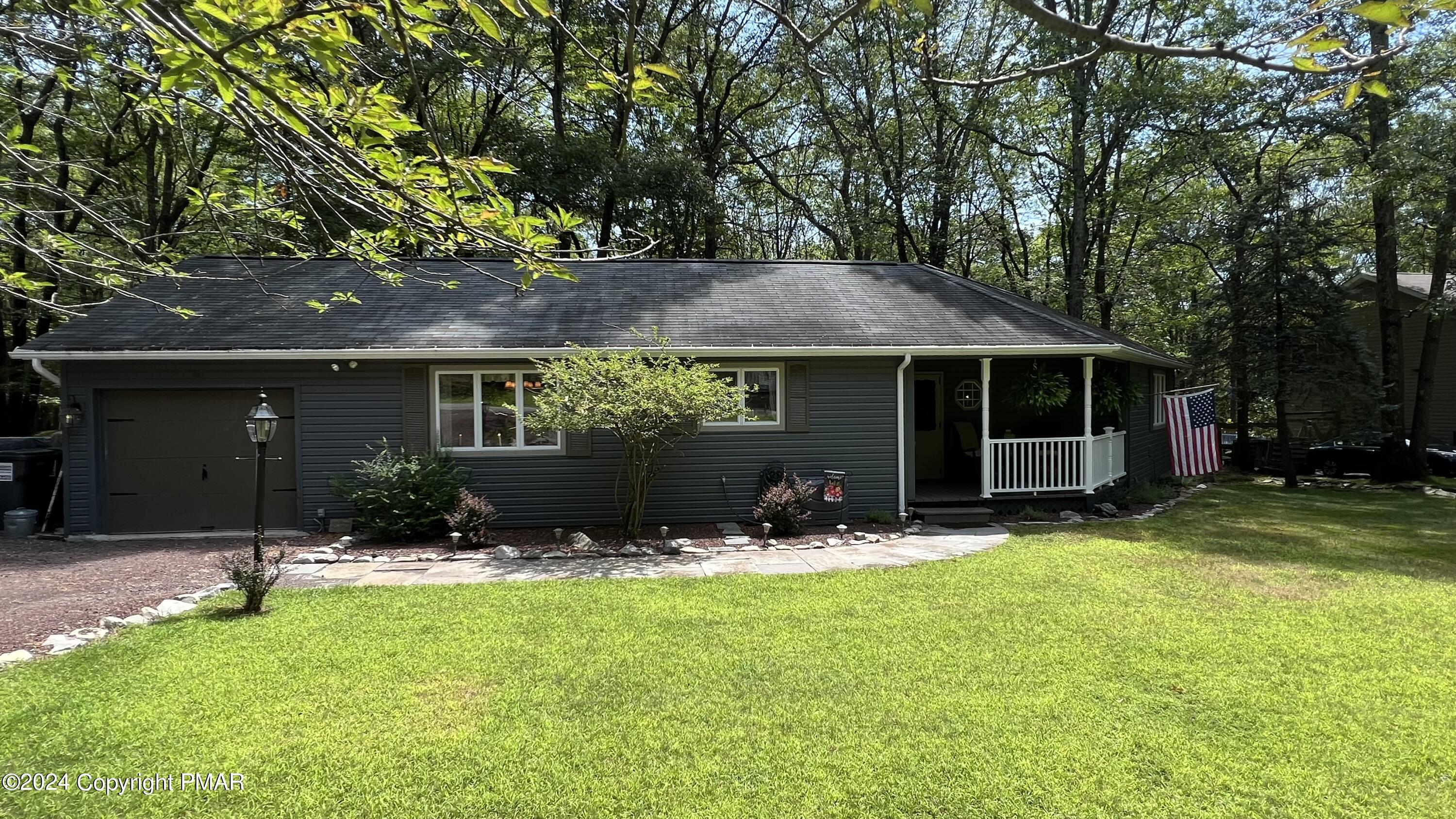 a front view of a house with a yard and tree