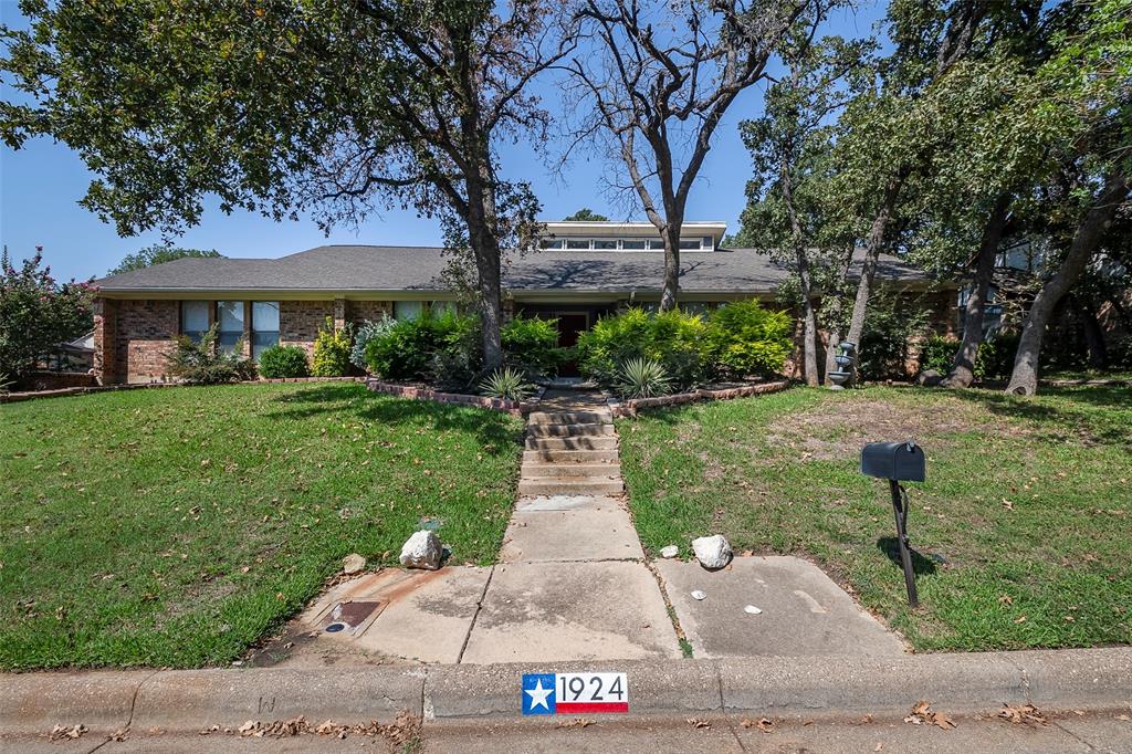 a front view of a house with a garden and yard